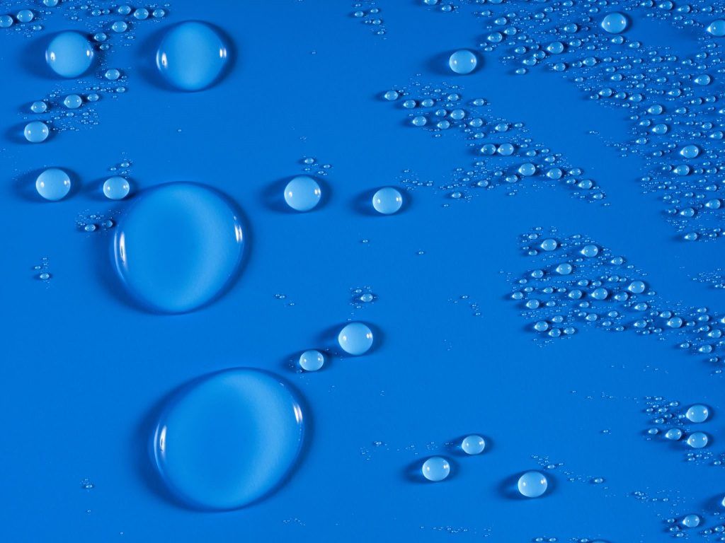 Gotas de aceite en agua sobre un fondo rojo